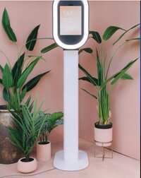 Introducing our Sleek Selfie Pod: a compact, modern, and affordable photo booth that fits beautifully into any space, like this space surrounded by plants