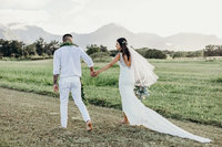 bride & groom walking through field