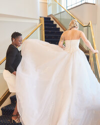 Wedding planner fixing bride's dress