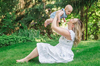 mom holding baby overhead in family photo