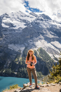 Woman standing in mountains with camera