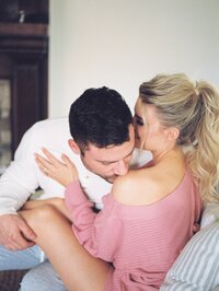 man kisses his girlfriend's shoulder