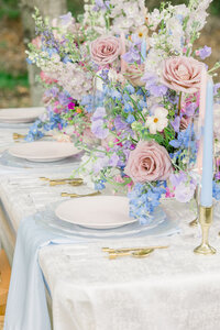 Elegant table adorned with beautiful blue and pink flowers, creating a stunning setting. Perfect for a memorable occasion in timeless photography.