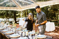 Wedding planners setting table under clear-top tent at Wellspring Spa near Mount Rainier National Park!