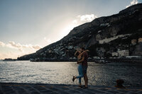 Kissing on the coast of Amalfi in Italy  with the hillside houses