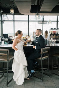 Bride and groom share a drink at the Bristol Hotel rooftop bar before their Bristol Train Station wedding