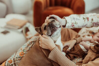 Mom and dad holding their dog's ears during a newborn session in Denver