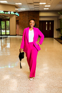 Lipscomb senior walking through business building wearing pink suit