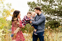 Mom and Dad playing with kids at their fall family photo session at Eldridge Park in Elmhurst