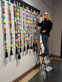 woman-hanging-art-in-gallery