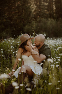 Bride and groom sit in a field of daisies at Dunton Hot Springs