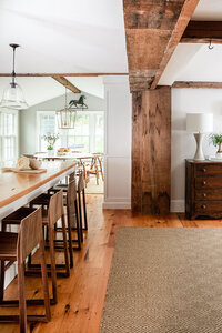 Hingham interior designer created a modern look in a historic New England home, blending original architecture with modern furniture for a fresh yet classic design.