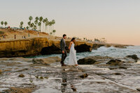bride and groom on ocean cliff