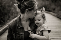 Mother kissing her daughter during photo session in Bellevue, WA
