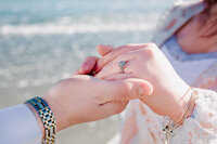 couples hands with engagement ring on beach in Rhode Island