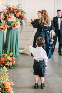 Ring bearer walking down the aisle at colorful Dallas wedding ceremony