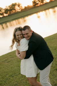 Birmingham AL photographer documents timeless and candid engagement photos of couple at pond in Montgomery hugging each other happily