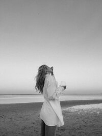 woman on beach with wine glass during personal brand photoshoot