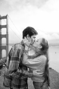 man and woman kissing with golden gate bridge in the background