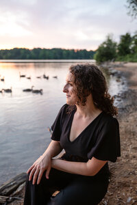 A-women-owned-business-owner-smiles-at-Loch-Raven-Park-in-Baltimore-County-Maryland-during-her-Branding-photos-near-Towson-Maryland