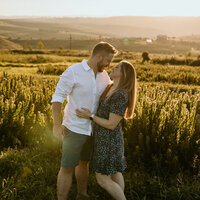 A couple kissing with the sun setting behind them