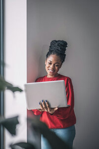 Woman in a suite happily looking at her laptop
