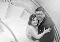 bride-groom-hugging-spiral-staircase-wedding