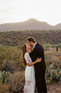 Film image of bride and groom kissing after desert elopement ceremony