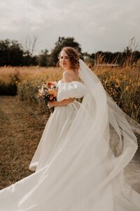 bridal portrait in field holding bouquet