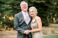 Portrait of parents of the bride holding hands and smiling