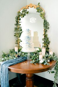 A beautiful wedding cake table display of a tiered cake with blue accents.