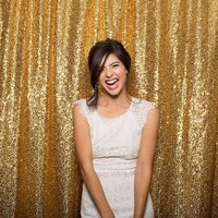 Girl laughing in photobooth with a gold glitter background