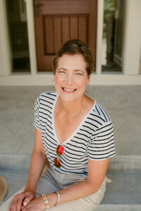 Confident middle-aged woman smiling on a front porch, representing the impact of following love-focused dating profile advice
