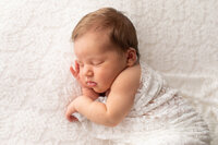 Sleeping baby boy with hands above blanket at NEWBORN PHOTOGRAPHY COLUMBIA MD session