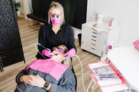Ottawa branding photographer Stacy Kenopic captures female dental professional during cosmetic procedure with modern tools and protective gear