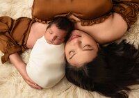 in home newborn session in los angeles mom and baby laying together