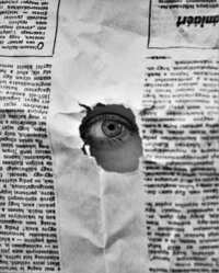 eye poking through newspaper