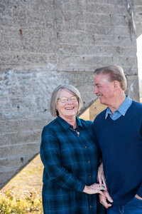 Grandmother and grandfather pose for photo of just the two of them wearing blue plaid and navy blue sweaters for extended family photos