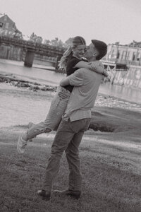 Joyful couple embracing by the water during a downtown Alabama couples session — black and white photo by EC Photography