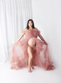 Women wearing pnk maternity gown with glam makeup during maternity photoshoot in Franklin Tennessee photography studio