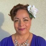 Melissa smiling in vintage waves and a custom handmade white hair flower by Your Girl Friday LV for her special event in Las Vegas.