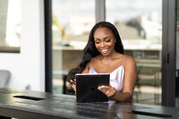 brand designer smiling into ipad while sitting at a table