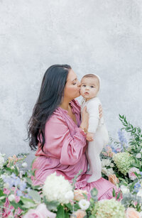 Mom holding her 9 month baby in front of South Jersey Newborn Photographer Tara Federico's handpainted backdrop