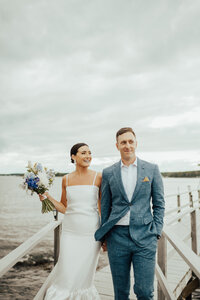 bride and groom walking on dock