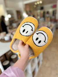 Yellow slippers with smiley face at boutique