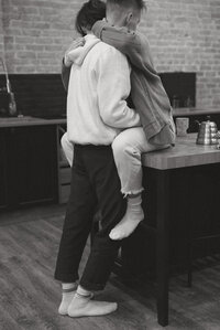 girl sitting on a counter hugging her boyfriend