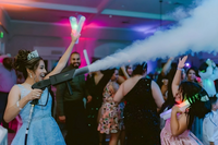 Wedding guests dance underneath ambient market lighting