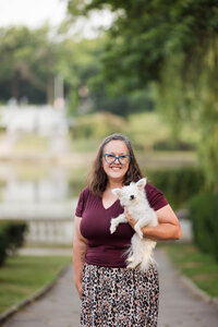 A picture of photographer Robyn White holding a small white fluffy dog.