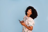 Woman laughing and smiling while texting
