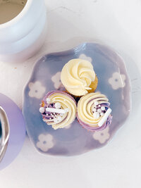 Delicious mini cakes with purple frosting and gems